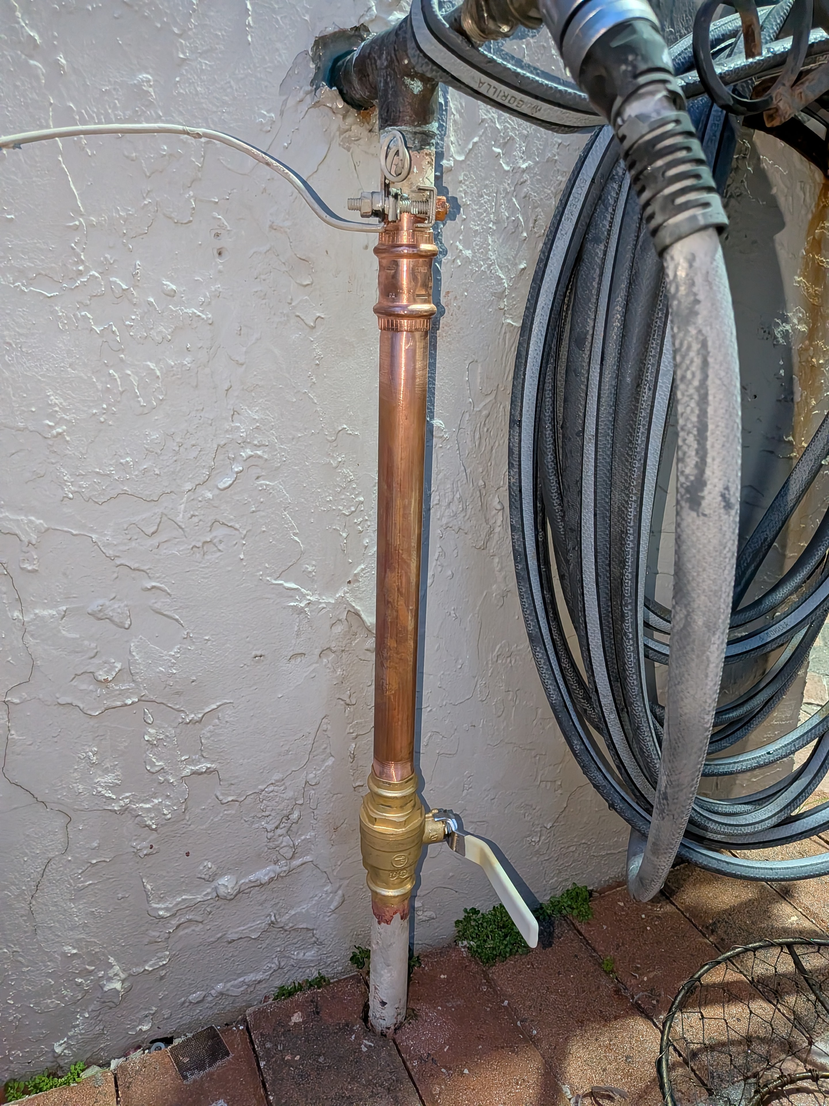 Copper water spigot with coiled hose