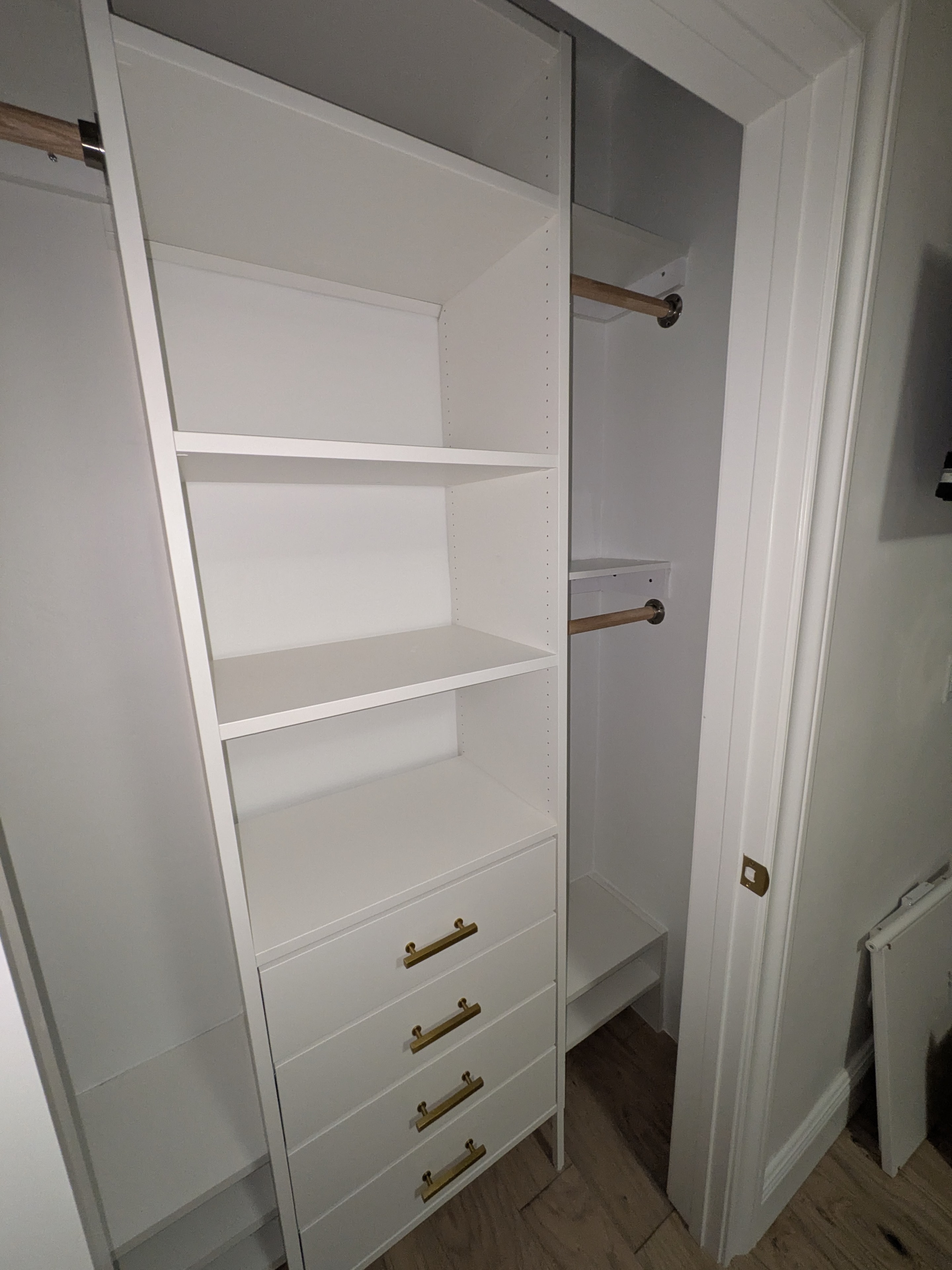 White closet shelving with drawers and rods